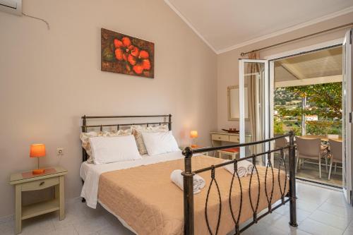 a bedroom with a bed and a balcony with a view at Minas Apartments in Divarata