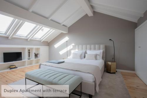 a bedroom with a large white bed and a tv at Alegria Residence in Porto