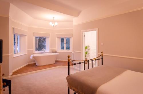 a bedroom with a bed and a tub in a room at The Alverbank Hotel in Gosport