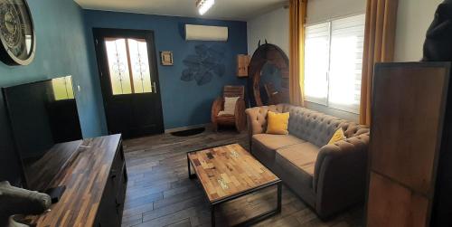 a living room with a couch and a coffee table at Superbe appartement classé 4étoiles avec piscine privée in Le Boulou