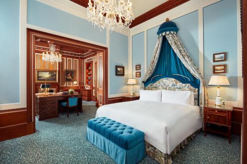 a bedroom with a bed with a blue canopy at The Lanesborough, Oetker Hotels in London