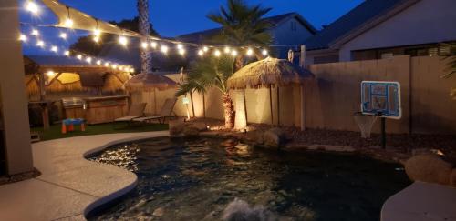 ein Schwimmbad mit Lichtern in einem Hinterhof in der Nacht in der Unterkunft Tiki Time Perfect Pool Home in Chandler! Sleeps 8! home in Chandler