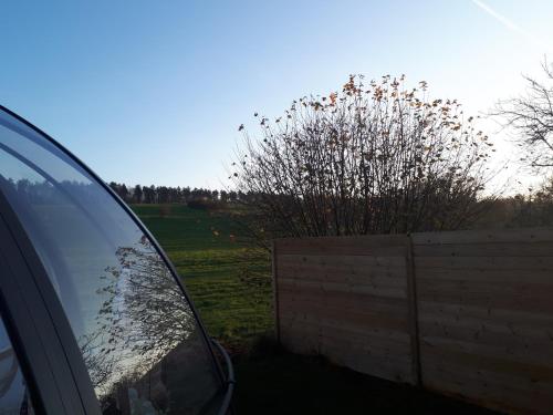 a car parked next to a fence and a bush at Au Clair de ma Bulle in Marche-en-Famenne