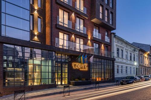 a hotel with a sign on the side of a building at Loft7 in Lviv