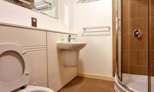 La salle de bains est pourvue de toilettes, d'un lavabo et d'une douche. dans l'établissement StayBrum Acadian City Centre Apartments Birmingham Chinatown, à Birmingham