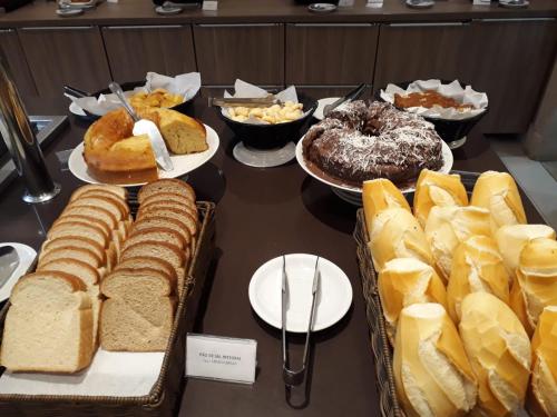 a table filled with different types of bread and pastries at Samba Tres Rios in Três Rios