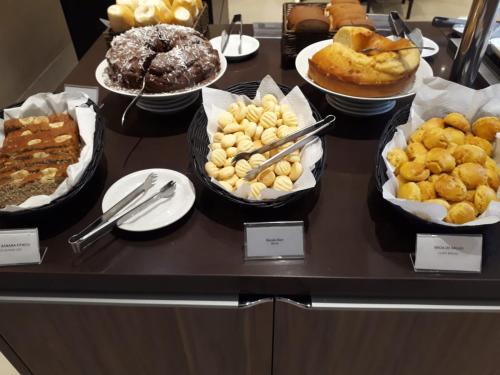 a table filled with different types of pastries and desserts at Samba Tres Rios in Três Rios