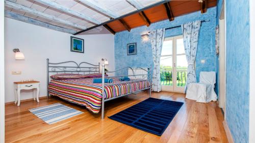 een slaapkamer met een bed en een blauwe muur bij Villa Tomani in Krmed