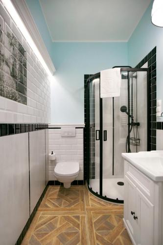 a bathroom with a shower and a toilet and a sink at Kamienica Boutique ApartHotel in Białystok