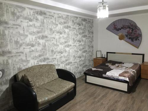 TuymazyにあるApartment on Komarova 12のベッドルーム1室(ベッド1台、椅子1脚、壁付)