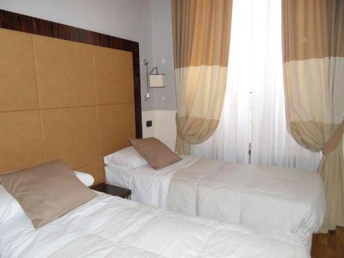a hotel room with two beds and a window at 939 Hotel in Rome