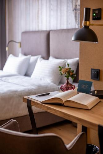 a desk with a book and a lamp and a bed at Loft7 in Lviv