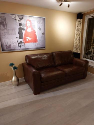 a brown leather couch sitting in a living room at Church Street Apartments in Inverness