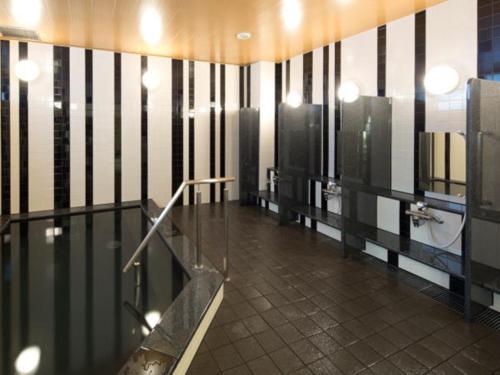 a bathroom with a urinal and a sink in it at Green Rich Hotel Kyoto Station South (Artificial hot spring Futamata Yunohana) in Kyoto