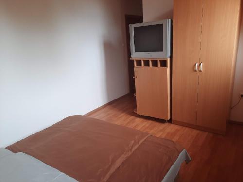 1 dormitorio con 1 cama y TV en un armario en Hat Testvér Fogadó, en Dömsöd