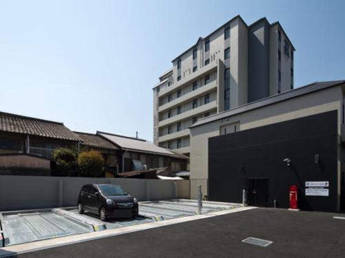 a car parked in a parking lot next to a building at Green Rich Hotel Kyoto Station South (Artificial hot spring Futamata Yunohana) in Kyoto