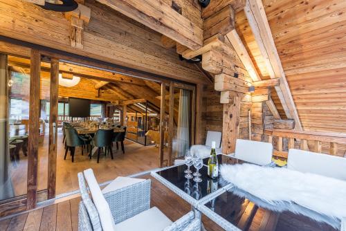 uma sala de jantar e sala de estar de um chalé de madeira em Le Lodge Rodzina, Luxueux chalet familial entièrement rénové avec Jacuzzi et Vue par LLA Selections em La Clusaz