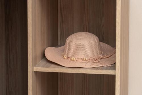 a pink hat sitting on a wooden shelf at Minas Apartments in Divarata