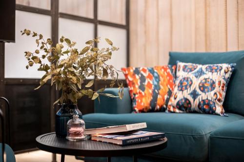 a living room with a blue couch and a table with books at Loft7 in Lviv