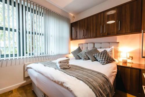 a bedroom with a large bed with wooden cabinets at Bishopsgate House in Coventry