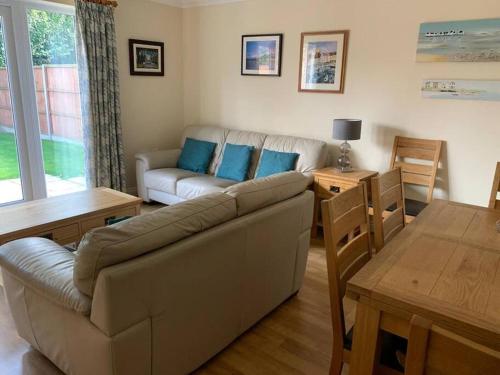 a living room with a couch and a table at Cheerful 3 bedroom home close to beach and High St in Sheringham