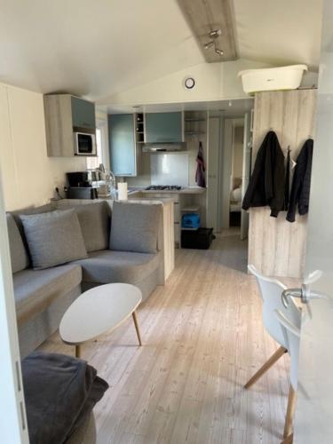un salon avec un canapé et une table et une cuisine dans l'établissement Mobil Home, à Fréjus