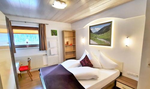 a bedroom with a white bed and a window at Heimat Apartments - Zillertal in Gerlos
