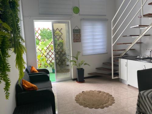 ein Wohnzimmer mit 2 Stühlen und einer Treppe in der Unterkunft Cesária Évora Loft in Praia