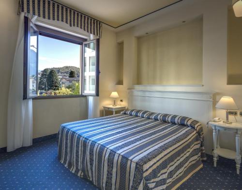 a hotel room with a bed and a window at Albergo Milano in Boario Terme