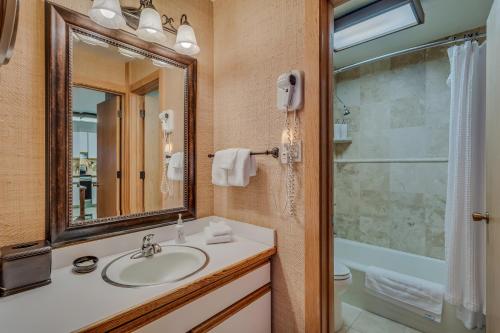 y baño con lavabo, espejo y bañera. en Laurelwood Condominiums 402 en Snowmass Village