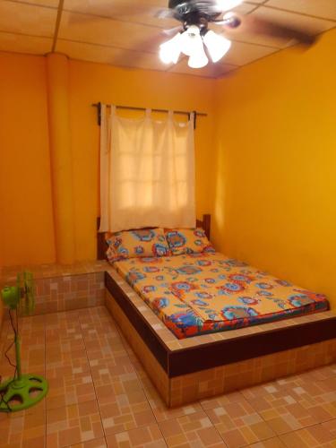 a bed in a room with yellow walls and a ceiling at Hotel Brisa Mar in Santa Catalina