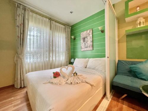 a bedroom with a white bed with green walls at The trust huahin resort condo greeny room in Hua Hin