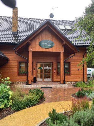 a building with a sign on the front of it at Leśna Polana in Radawa