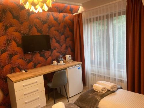 a bedroom with a desk and a bed with a television at Leśna Polana in Radawa