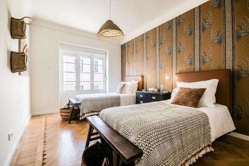 1 dormitorio con 2 camas y pared de madera en Casas da Tapada, en Lisboa