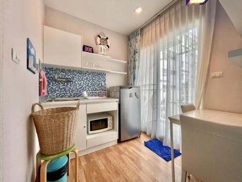 a small kitchen with a refrigerator and a window at The trust huahin sky room condo pool view in Hua Hin