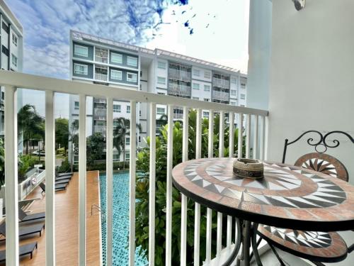 a balcony with a table and a building at The trust huahin sky room condo pool view in Hua Hin