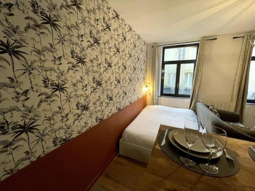 a hotel room with a bed and a wall with a wallpaper at Magnifique studio Metz Coeur Historique in Metz