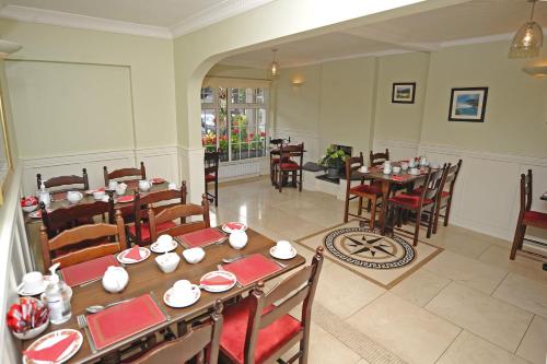 uma sala de jantar com mesas e cadeiras num restaurante em Clooneen House em Westport