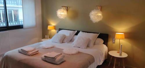 - une chambre avec un grand lit et des serviettes dans l'établissement La Maison du Petit Hutin, à Reims