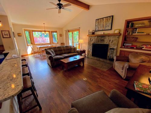 a living room with a couch and a fireplace at O8 Renovated Forest Cottage Townhome with great Mt Washington views fast wifi Walk to skiing in Carroll