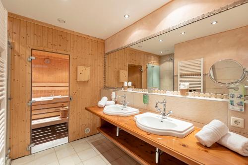 a bathroom with two sinks and a large mirror at Wellness Aparthotel Panorama Alpin - Ferienwohnungen Jerzens im Pitztal in Jerzens