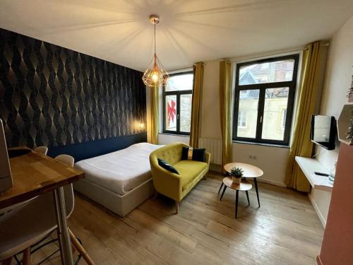 Habitación pequeña con cama y silla amarilla en Cosy studio lumineux Metz hypercentre, en Metz