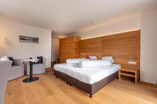 a bedroom with a large bed and a couch at Wellness Aparthotel Panorama Alpin - Ferienwohnungen Jerzens im Pitztal in Jerzens