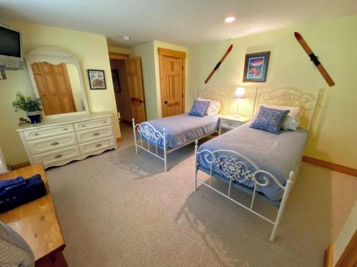 a bedroom with two beds and a mirror at E5 Beautiful Bretton Woods slopeside home amazing views of Mount Washington Hot Tub AC in Carroll
