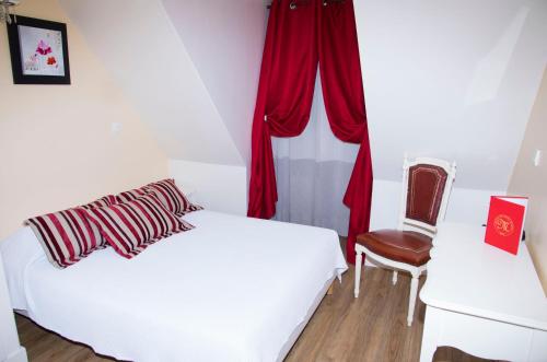 a bedroom with a bed and a chair and a window at Hôtel du Mont Blanc in Paris