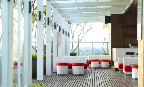 a room with red and white tables and chairs at ibis Styles Yogyakarta in Yogyakarta