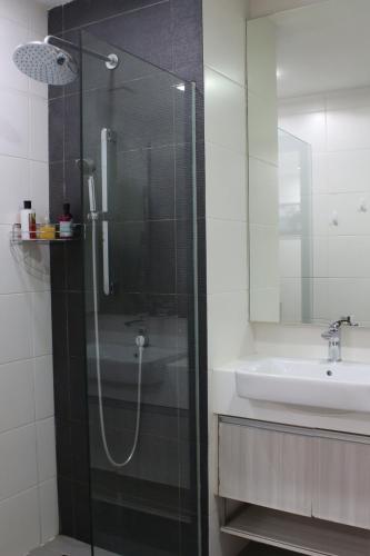 Un baño con ducha de cristal y lavabo. en Suasana Suites D'homestay JB Town, en Johor Bahru