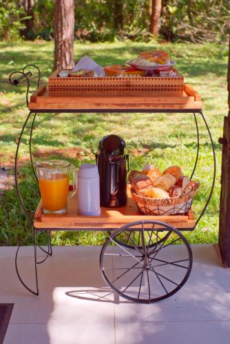 a table with a tray of food and a basket of bread at Verde da Mantiqueira Chalés in Visconde De Maua