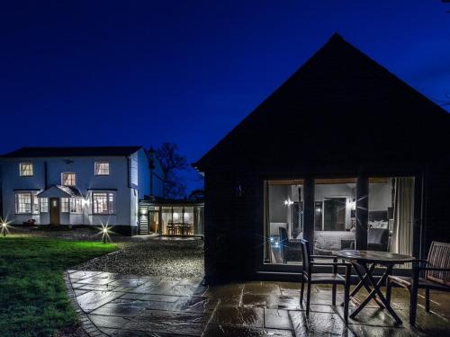 a house with a table and chairs outside at night at Eagle Mill Luxury Rooms in Huntingdon